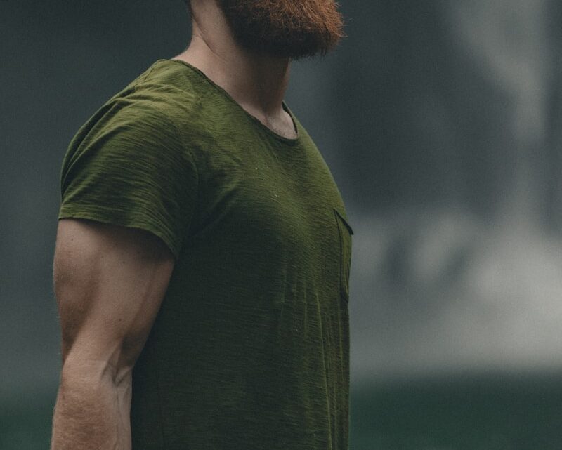 man wearing green crew-neck t-shirt looking upwards